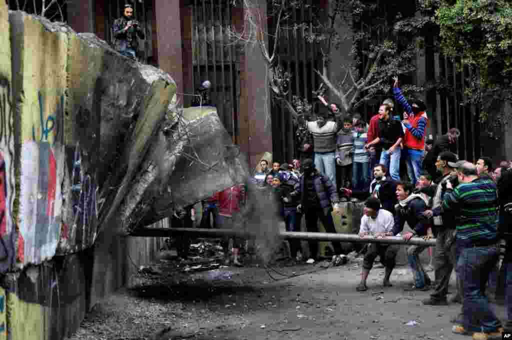 Egyptian protesters try to tear down a cement wall built to prevent them from reaching parliament and the Cabinet building near Tahrir Square in Cairo.