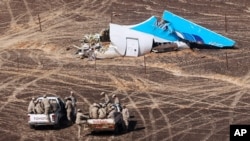 FILE - In this photo made available on Nov. 2, 2015, and provided by Russian Emergency Situations Ministry, Egyptian Military on cars approach a plane's tail at the wreckage of a passenger jet bound for St. Petersburg in Russia that crashed in Hassana, Egypt.