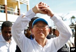 U.N. Secretary-General Ban Ki-moon makes a gesture of solidarity to people whose homes were destroyed by Hurricane Matthew, as he visits a school where they have sought shelter in Les Cayes, Haiti, Oct. 15, 2016.