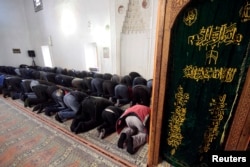 FILE - Muslim Tatar men pray in the Great Khan mosque (Khan Dzhami) in the Crimean town of Bakhchisaray, March 13, 2015.