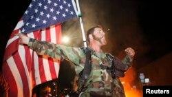 Un miembro del grupo Veteranos por la Paz protesta en Oakland, California la decisión del gran jurado en Ferguson, al extenderse las manifestaciones a 170 ciudades alrededor del país.