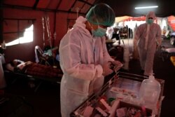 Petugas kesehatan bersiap membantu pasien COVID-19 di tenda sementara di luar ruang gawat darurat rumah sakit pemerintah di Bekasi, 25 Juni 2021. (Foto: REUTERS/Willy Kurniawan)