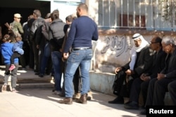 Voters queue to cast their ballots at a polling station in Qamishli, Syria, Dec. 1, 2017.