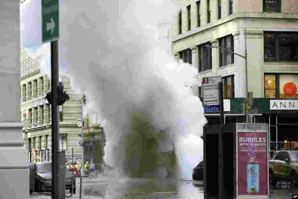  A thick cloud of steam billows on New York's Fifth Avenue in Manhattan. A steam pipe exploded beneath the street, sending chunks of asphalt flying, and a geyser of white steam stories into the air, which forced pedestrians to take cover.