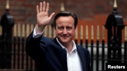 Britain's Prime Minister David Cameron waves as he leaves the Conservative Party headquarters in London, Britain, May 8, 2015.