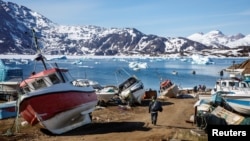 A man walks to his boat past a number of abandoned and dry-docked boats in the town of Tasiilaq, Greenland, June 15, 2018.