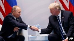 Le président Donald Trump échange une poignée de main avec son homologue russe Vladimir Poutine lors du Sommet du G20, à Hambourg, 7 juillet 2017