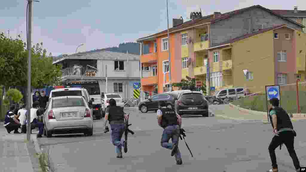 Des policiers turcs se mettent à l'abri au cours d'un échange de tirs après une explosion dans le quartier de Sultanbeyli, Istanbul, 10 août 2015.
