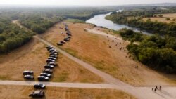 Official vehicles line up along the bank of the Rio Grande near an encampment of migrants, many from Haiti, near the Del Rio International Bridge, in Del Rio, Texas, Sept. 21, 2021.