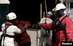 Migrants are rescued by staff members of the MV Aquarius, a search and rescue ship run in partnership between SOS Mediterranee and Medecins Sans Frontieres in the central Mediterranean Sea, June 10, 2018. (Karpov handout via Reuters)