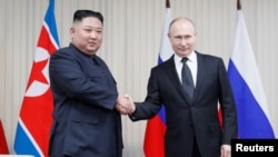 Presiden Rusia Vladimir Putin (kanan) berjabat tangan dengan Pemimpin Korea Utara, Kim Jong-un di Pulau Rusky, Vladivostok, Rusia, 25 April 2019.