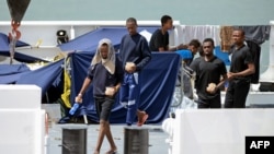 Migrants gather on the deck of the Italian Coast Guard vessel 'Diciotti' in the Sicilian port of Catania, on Aug. 23, 2018 as they wait to disembark following a rescue operation at sea.