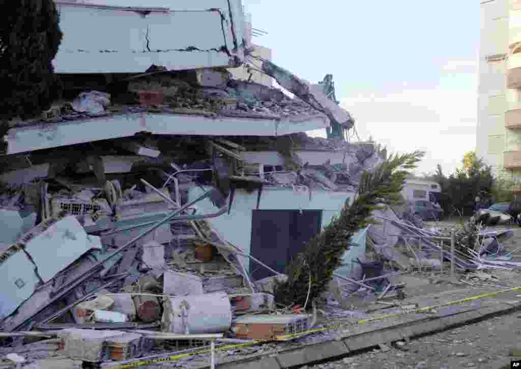 A man passes next to a damaged building after a magnitude 6.4 earthquake in Durres, western Albania. A strong earthquake has shaken Albania, killing at least four people were killed and 150 others were injured.