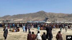 Mamia ya watu wakusanyika karibu na ndege ya Air Force C-17 ya usafiri ya Marekani katika eneo la Uwanja wa Ndege wa Kimataifa wa Kabul, Afghanistan, Agosti 16, 2021.(AP Photo/Shekib Rahmani)