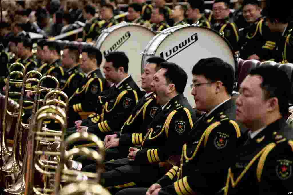A member of military music band yawns while others listen to Chinese Premier Wen Jiabao's speech at the annual National People's Congress at Beijing's Great Hall of the People, March 5, 2013.
