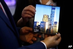 A man holds the new Huawei Mate X foldable 5G smartphone during the Mobile World Congress wireless show, in Barcelona, Spain, Feb. 26, 2019.