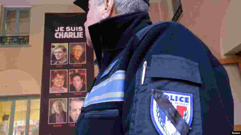 Un agent municipal de la police française porte une barre noire sur son emblème officiel de la police comme un symbole de deuil des fusillades de Charlie Hebdo, à Nice, en France, le 8 janvier 2015.