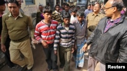 Indian police personnel escort men, tied with rope, who are accused of a gang-rape, to a court at Birbhum district in the eastern Indian state of West Bengal, Jan. 23, 2014.