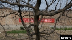 A banner warning against illegal land occupancy is placed on a wall in Santai, one part of the new special economic zone Xiongan New Area, China, April 6, 2017.
