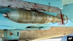 In this photo made from video released by Russian Defense Ministry official web site on Nov. 20, 2015, "For Paris" is written on a bomb attached to a Russian war plane in preparation for a combat mission in Syria.