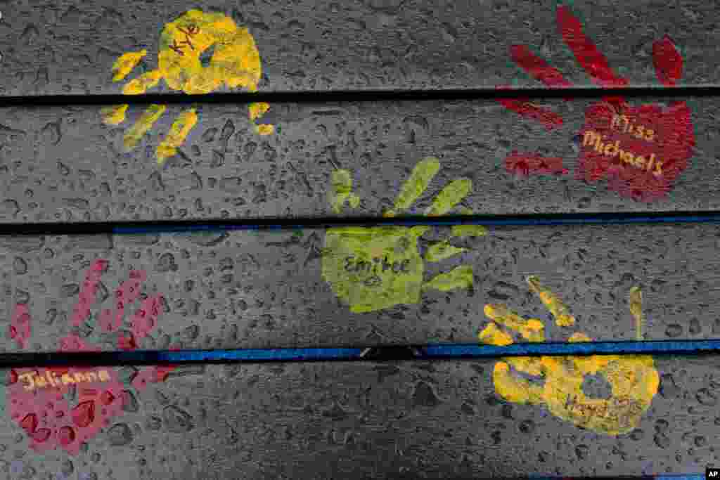 Painted handprints with names of teachers and students are on a playground bench at the new Sandy Hook Elementary School in Newtown, Connecticut. The names are not those of people killed in the 2012 massacre at the school.