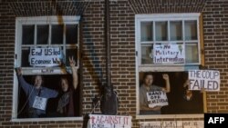 Los activistas son vistos posando en la ventana de la embajada venezolana ocupada después de que agentes federales llegaron para abrir la puerta en Washington, el 13 de mayo de 2019.