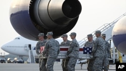 An Army carry team carries the transfer cases containing the remains of Army Spc. Scott D. Smith of Indianapolis, Indiana upon arrival at Dover Air Force Base, Delaware on June 21, 2011.