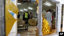 Detectives inspect the scene of an explosion inside the God's House of Miracles International Church in Nairobi, site of the April 29, 2012 grenade attack.