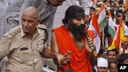 An Indian senior policeman detains yoga guru Baba Ramdev, right, during an anti-corruption protest in New Delhi, India, August 13, 2012. 