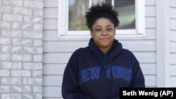 Courtenay Brown poses for a picture in front of her home in Newark, N.J., Tuesday, April 28, 2020. (AP Photo/Seth Wenig)