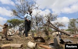 A security officer walks past a temporary stall destroyed after a suicide car bomb went off at the entrance of Somalia's biggest port in its capital, Mogadishu, Dec. 11, 2016.