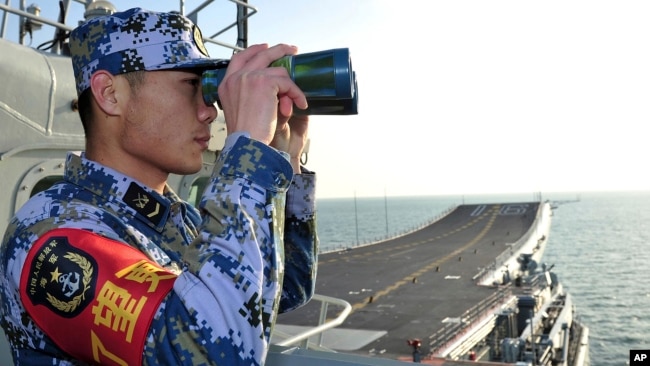 Một lính hải quân Trung Quốc trên hàng không mẫu hạm đầu tiên của nước này là Liêu Ninh.