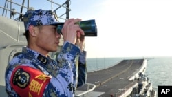 Seorang awak kapal armada laut China (PLA) memantau laut China Timur dari kapal induk Liaoning, 26 November 2013 (Foto: dok). Pemerintah China mulai memberlakukan ijin penangkapan ikan di Laut China Selatan bulan ini.