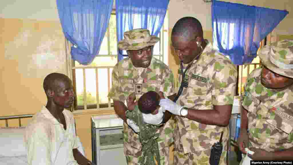 Le personnel médical militaire examine le bébé de Amina Ali à Maiduguri.