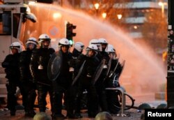 Policijske snage čuvaju stražu dok ljudi protestuju protiv mera korona virusa (COVID-19) u blizini Evropske komisije u Briselu, Belgija, 21. novembra 2021.