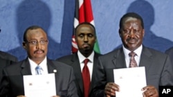 Somalia's Prime Minister Abdiweli Mohamed Ali (L) and his Kenyan counterpart Raila Amollo Odinga display the joint communique issued following their talks in Kenya's capital Nairobi, October 31, 2011.
