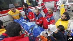 Twenty-seven year-old earthquake survivor Gozde Bahar is carried to an ambulance by rescue workers in Ercis, near the eastern Turkish city of Van, October 26, 2011.