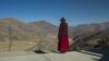 Religieuse bouddhiste devant une vallée du comté de Sertar dans la préfecture autonome tibétaine de Garze enclavée dans la province du Sichuan en Chine, 8 décembre 2015.