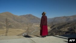 Religieuse bouddhiste devant une vallée du comté de Sertar dans la préfecture autonome tibétaine de Garze enclavée dans la province du Sichuan en Chine, 8 décembre 2015.