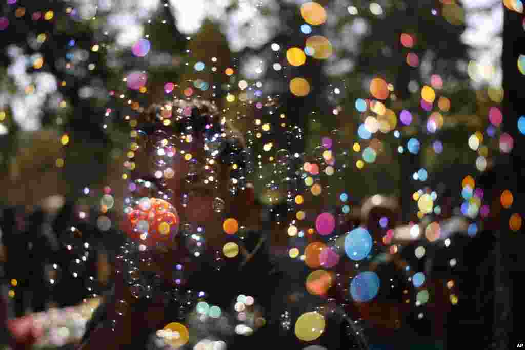 An Egyptian vendor blows bubbles at the Giza Zoo, as the country marks Sham el-Nessim, or &ldquo;smelling the breeze,&rdquo; in Giza. The holiday signifies the arrival of Spring, a uniquely Egyptian tradition, practiced since the days of the Pharaohs.