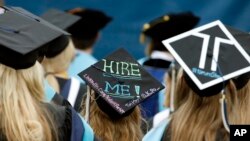 FILE - Graduates, including one looking for a job, are seated during George Washington University's commencement exercises on the National Mall in Washington, May 17, 2015.