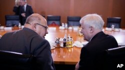 German Interior Minister Horst Seehofer, right, talks with Economy Minister, Peter Altmaier, left, prior to the last cabinet meeting of the German government for this year, at the chancellery in Berlin, Wednesday, Dec. 19, 2018.