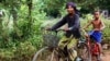 FILE PHOTO - Im Chaem, a former Khmer Rouge cadre, is pictured riding a bike along with her grandson in Along Veng, Oddar Meanchey province, Cambodia, Sunday, April 23, 2017. (Sun Narin/VOA Khmer)