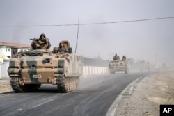 Turkish army tanks and armored personnel carriers move toward the Syrian border in Karkamis, Turkey on Aug. 25, 2016.