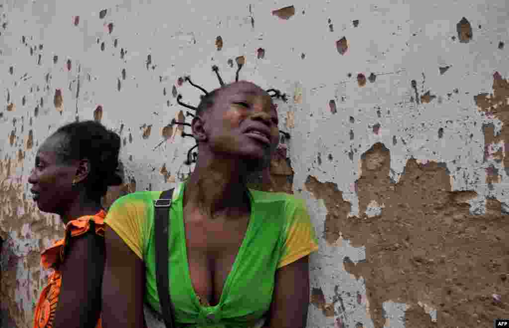 Two women mourn the death of two relatives killed in the 5th district, one the of the city's central neighborhoods, in Bangui, Central African Republic. The International Criminal Court in the Hague said on February 7 it had opened an initial probe into war crimes in CAR.