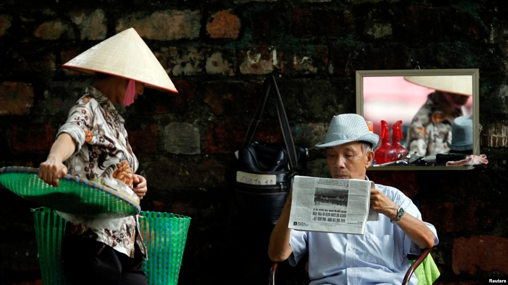 Một người dân đọc báo trên đường phố Hà Nội. Theo thống kê của CPJ, Việt Nam kết án tù 11 nhà báo trong năm qua và trở thành một trong những quốc gia "cai ngục" tồi tệ nhất thế giới.