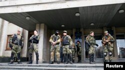 Para anggota pasukan bersenjata pro-Russia berjaga di depan kantor pemerintah di Slovyansk, wilayah Donetsk, Ukraina Timur (14/4).