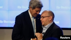 Le secrétaire d'Etat américain John Kerry saluant Jason Rezaian, journaliste du Washington Post lors d'une cérémonie de la rédaction du Washington Post à Washington, le 28 janvier 2016. (REUTERS / Gary Cameron).
