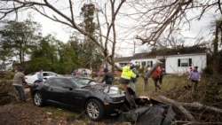 Members of the community work to clear debris off of a car after a tornado off in Bowling Green, Ky., Dec. 11, 2021.