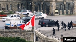 Armed RCMP officers approach Centre Block on Parliament Hilll following a shooting incident in Ottawa October 22, 2014. 
